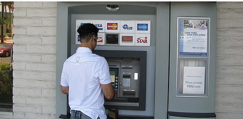 Foto de un caballero con audífonos usando un telecajero.