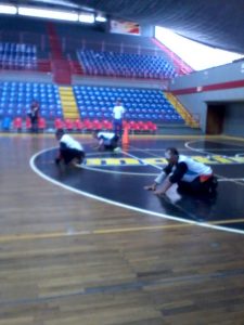 Tres de los integrantes de uno de los equipos masculinos del Zulia en la cancha de juego durante uno de los encuentros del torneo, con sus uniformes negro y azul.