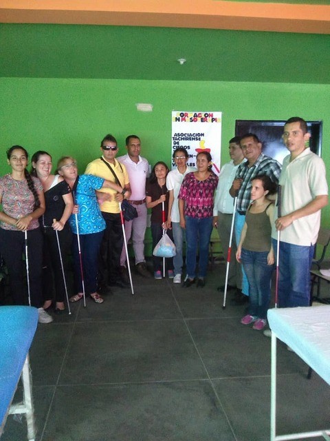 Participantes del curso de masoterapia de ATCIDEV, de pie, con sus bastones.