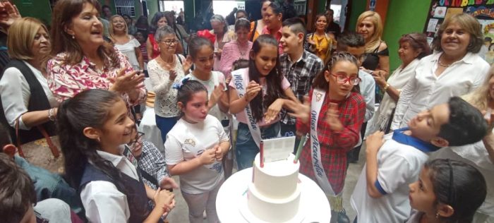 Asistentes a la celebración cantando cumpleaños. 